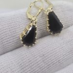 Coffin shaped black spinel earrings in fierce yellow gold claw setting